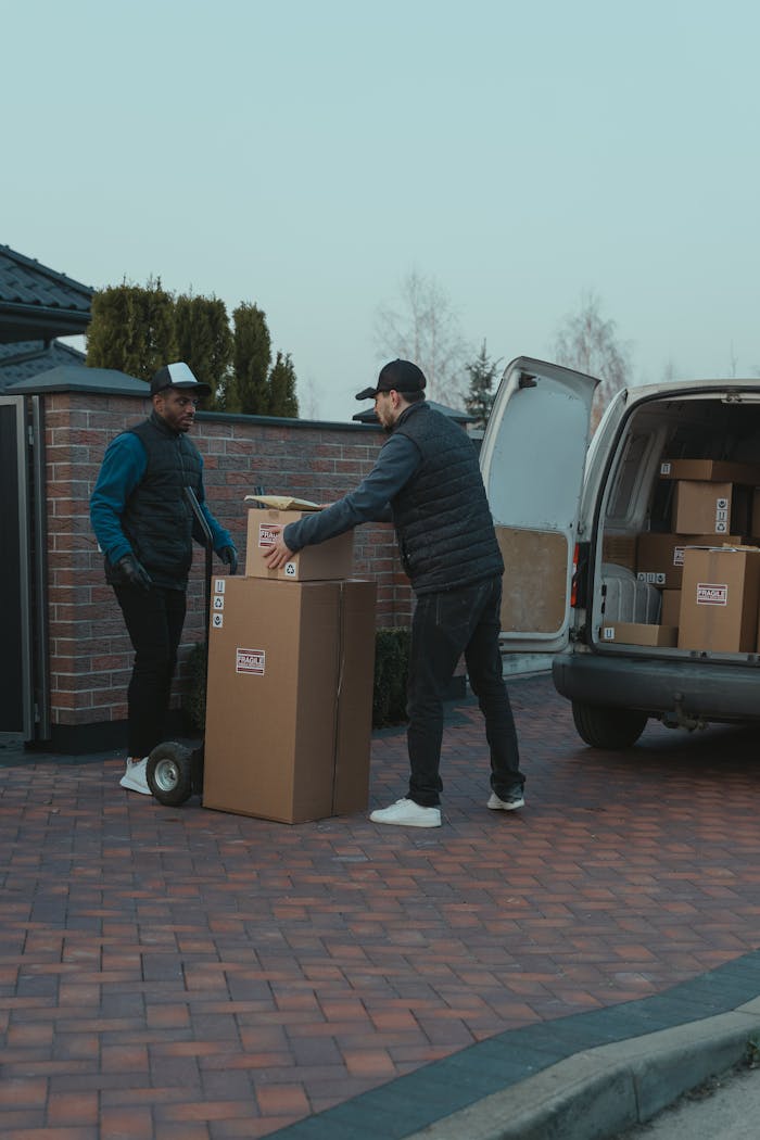 services-02 Two delivery men working together to unload boxes from a van in a residential area.