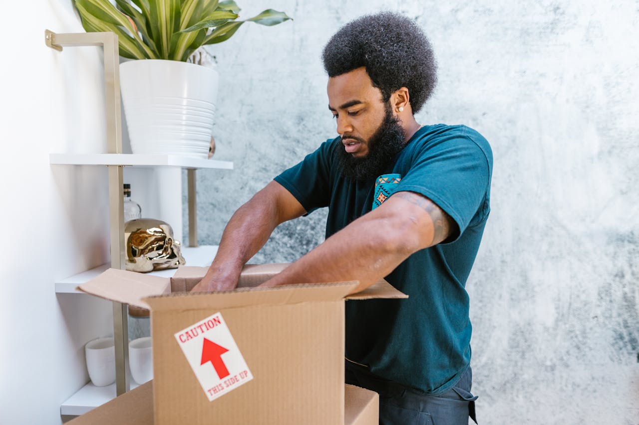 our-experience A professional mover packs a fragile item into a box in a stylish room.
